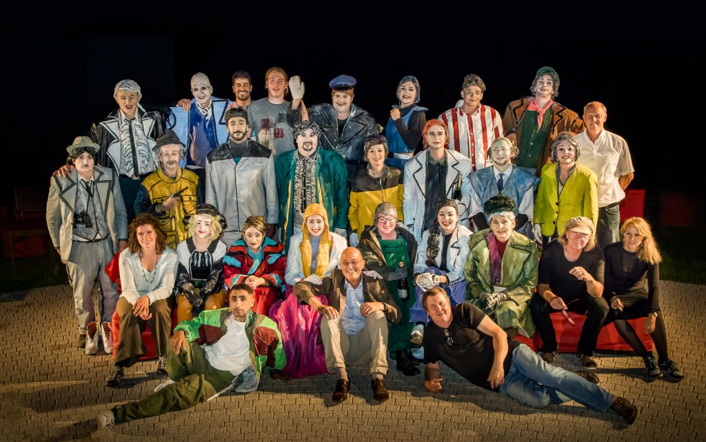 Ensemble in bunten Kostümen beim Gruppenbild bei Nacht