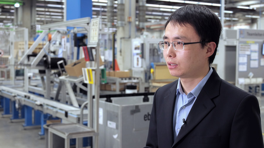 Ingenieur im Interview vor einer Fertigungslinie